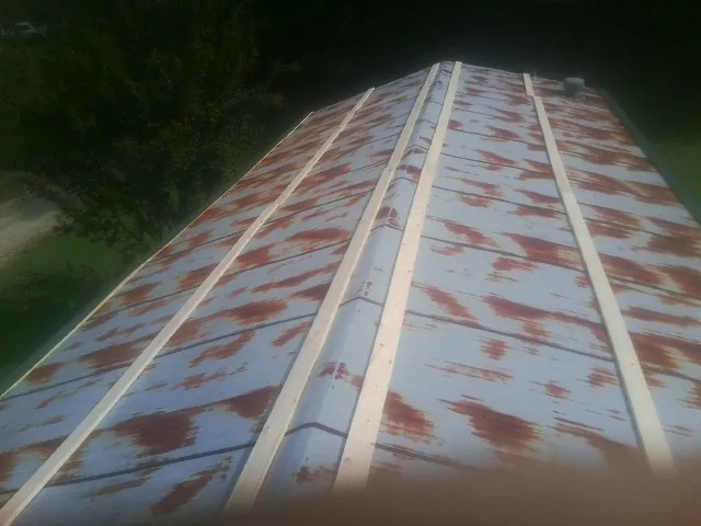 Rusted metal roof panels with new wood purlins before replacement — Storm Damage Roof Repair in Grovetown by Roofing Brothers