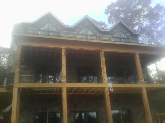 Dormers and porch framing on a large log home under construction — Roof Coating work by our crew in Grovetown