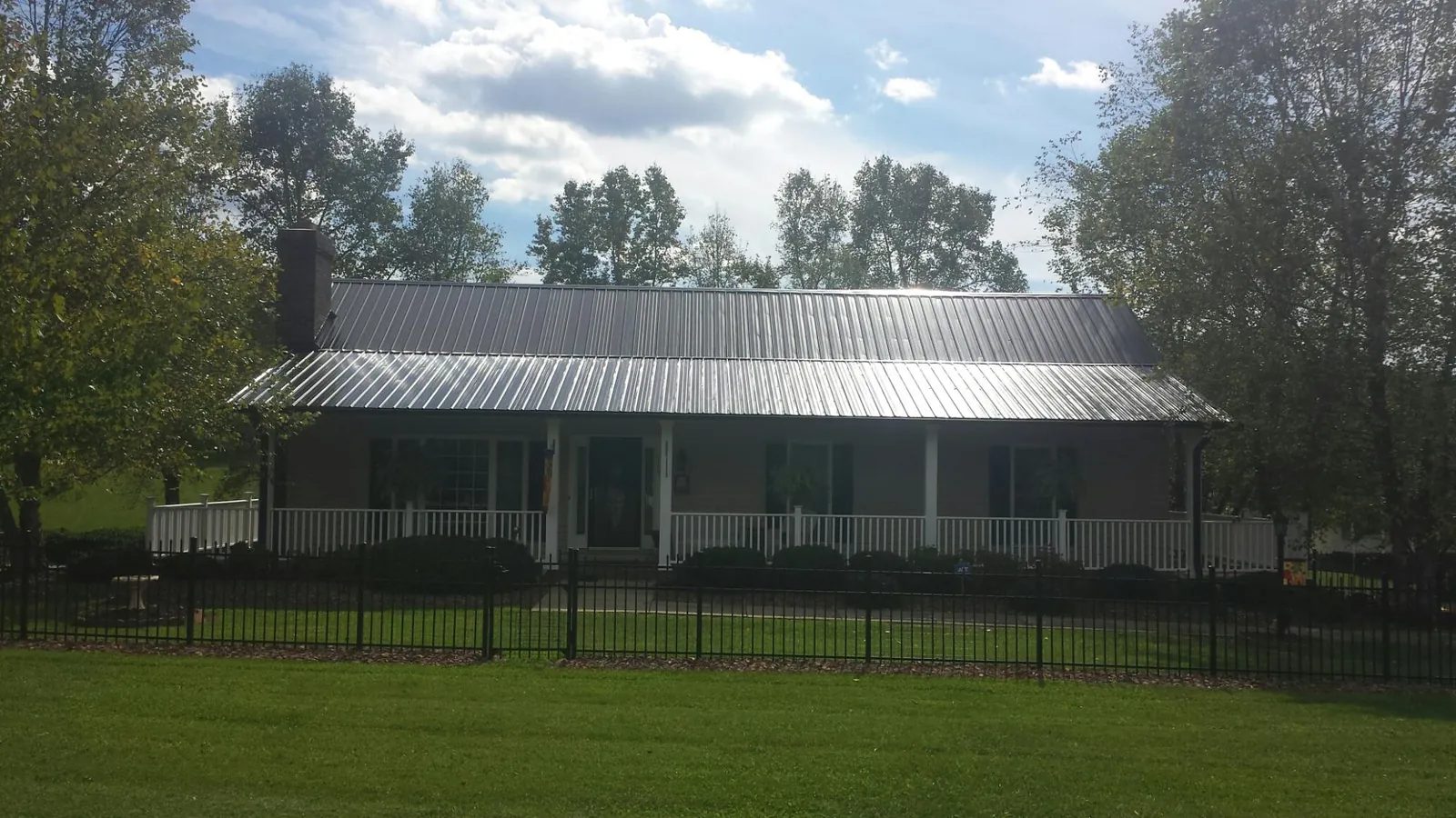 Gray metal roof on a brick ranch with a full width front porch — Gutter Guard Installation work by our crew in Grovetown
